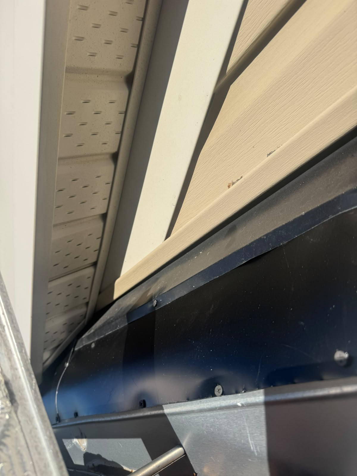 Completed metal flashing along a roof and wall junction